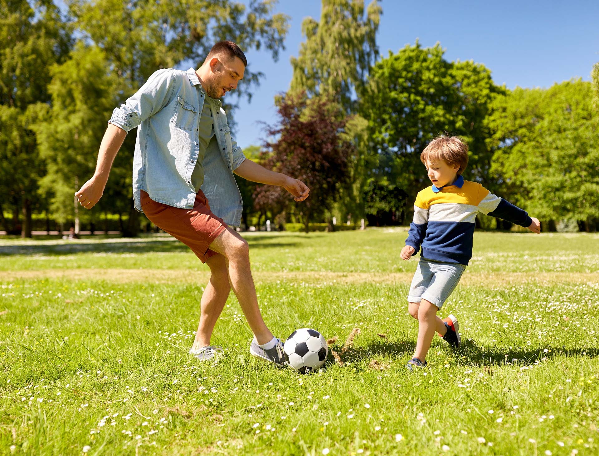Dad and son playing football